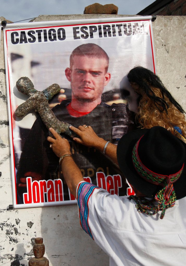 A shaman performs a ritual for the spiritual punishment of Joran van der Sloot, whose picture is posted on the wall, before Van der Sloot’s trial opened in Lima, Peru, on Friday.