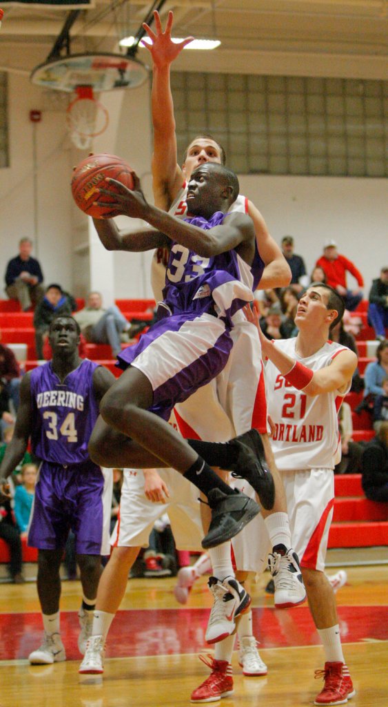 The path to the basket was never easy Friday night: Labson Abwoch of Deering looks for a way to slip past Jack Tolan of South Portland during Deering’s 40-29 victory.