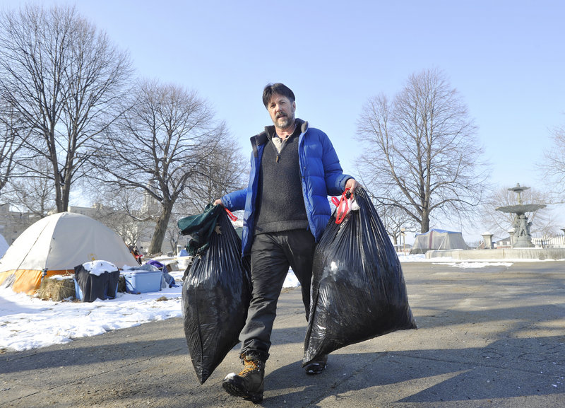 Bob Klotz, a volunteer from South Portland, carries trash he collected during the Occupy Maine cleanup on Saturday to a collection site at the Lincoln Park tent city. Though not a camper at the park, Klotz said he wanted to help and sees “the value of keeping it a little neater.”