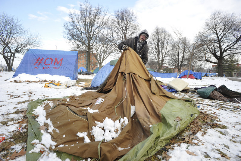 Ray Woodburn, a resident of the Occupy Maine encampment in Portland, breaks down an unoccupied tent as protesters and volunteers spruced up Lincoln Park on Saturday. The group plans a “grand re-occupation” event at the park at 1 p.m. today.