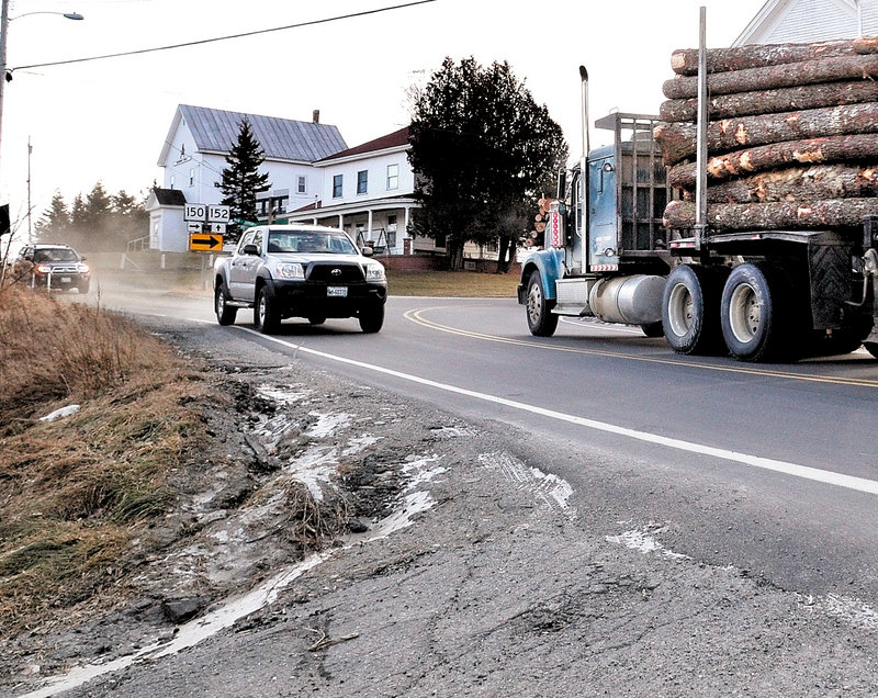 Vehicles negotiate the sharp turn on Route 150 in Cambridge, where a truck crashed into the nearby Cambridge General Store last August. The Maine Department of Transportation plans to install warning lights near the curve that will flash if drivers exceed the speed limit.
