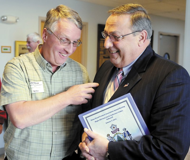 Phil Bibeau, left, of Westminster, Mass., talks with Gov. Paul LePage on Monday at the Maine Wood Products Association meeting in Hallowell.