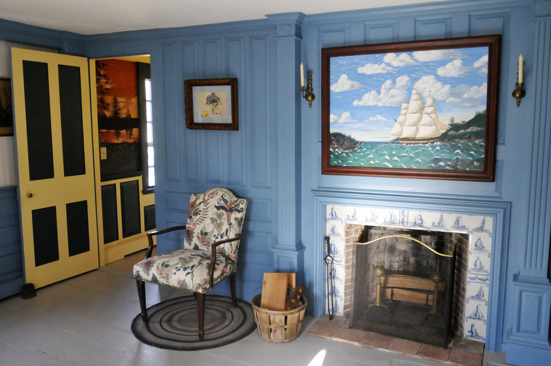 An upstairs bedroom boasts a fireplace bordered with Dutch tiles and a painting by Marjorie Cantara.