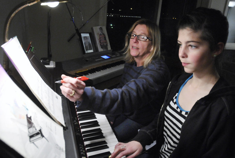 Denise Calkins gives a piano lesson last week to Amelia Papi, 12, of South Portland on a keyboard donated to her so she could continue teaching. Calkins received dozens of offers of replacement instruments after losing two pianos in a fire in November.