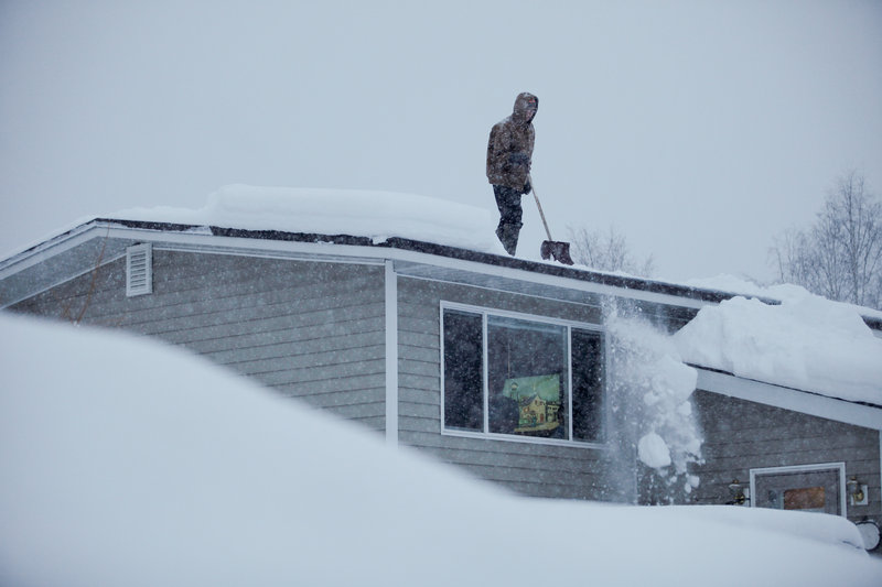 Doug Hamrick shovels snow off of his family’s roof in Anchorage. The National Weather Service predicted a snowfall of 8 to 16 inches Thursday, putting Anchorage on track to have the snowiest winter on record.