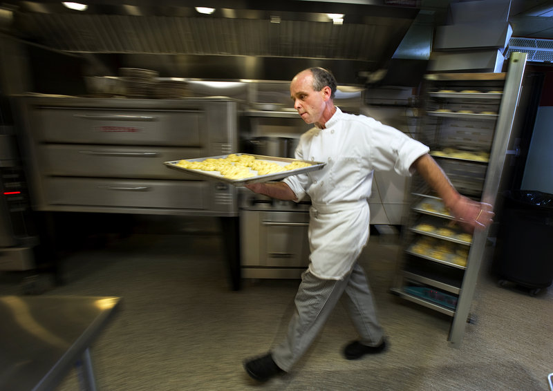 Ed Foley carries a tray of croissants to his convection oven shortly after 4 a.m.