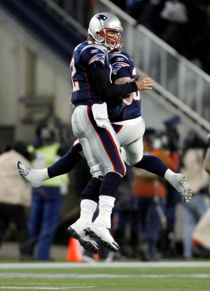 Tom Brady celebrates with Danny Woodhead after throwing a 61-yard touchdown pass to Deion Branch late in the first half. New England ended a three-game playoff losing streak with a 45-10 win.