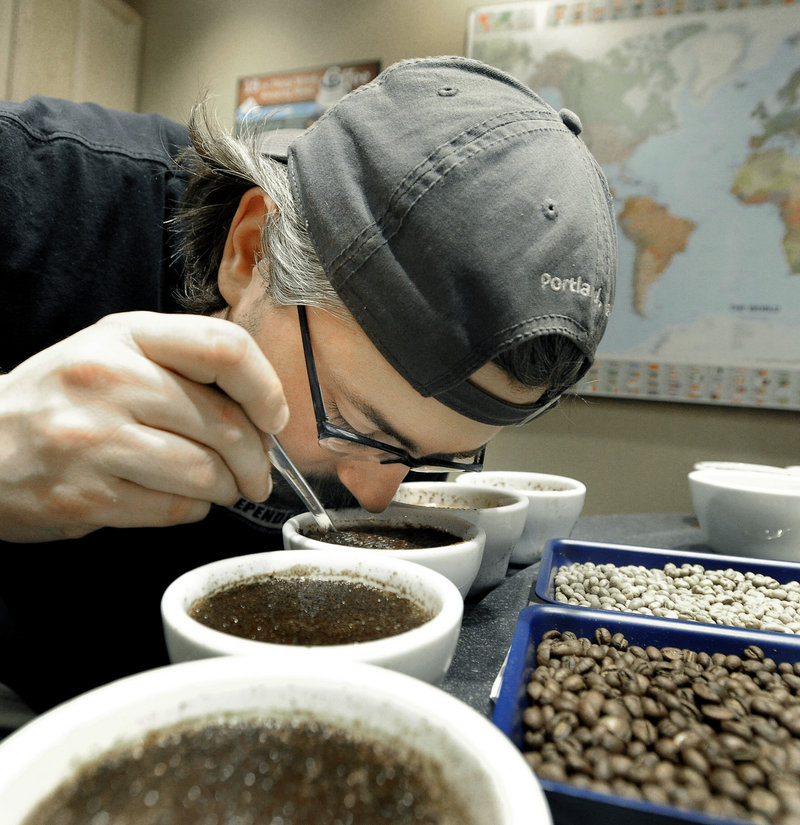 Dylan Hardman “breaks the crust” to release a coffee’s aroma.
