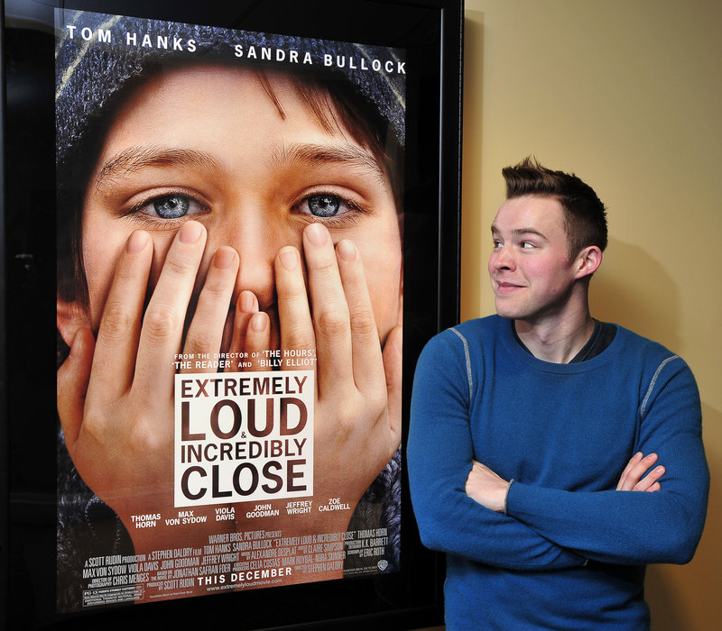 Alexander Libby poses with a poster for “Extremely Loud & Incredibly Close” at the Nordica Theatre in Freeport, where he recently hosted a private screening.