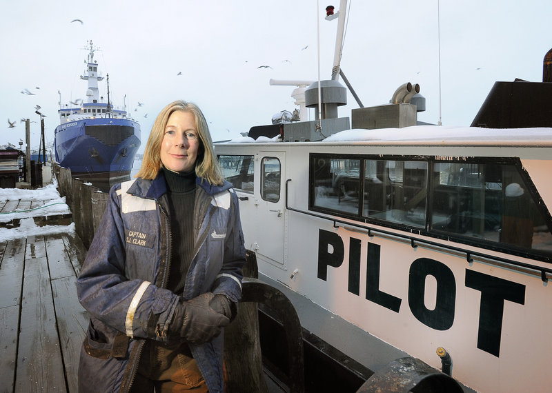 Capt. Susan Clark of Portland Pilots Inc. stands Tuesday near one of the boats she uses when guiding oceangoing vessels through Portland Harbor. Disasters like the one in Italy are less likely here since any vessel that sits 9 feet or deeper in the water must have a Maine pilot, independent of any shipping company, guiding it when it enters Maine waters.