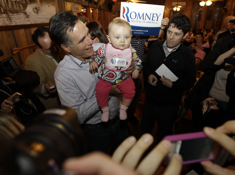 GOP presidential candidate Mitt Romney picks up Lauryn Penfield, 7 months old, as he makes an stop at Hudson’s Smokehouse barbecue in Lexington, S.C., Wednesday.