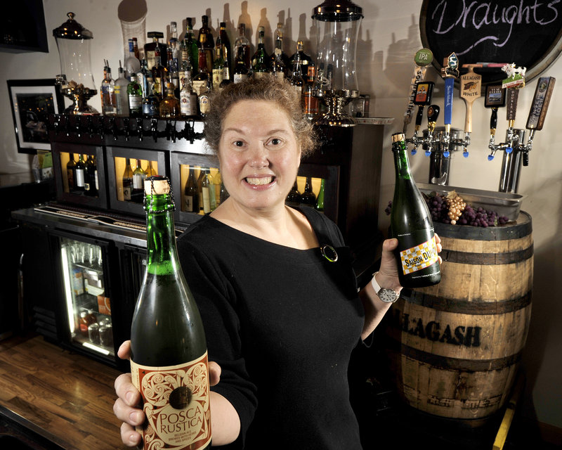 “Silly’s With a Twist” bar manager Shelley Kelley displays big-bottle specialty beers offered by the glass at the recently opened restaurant.