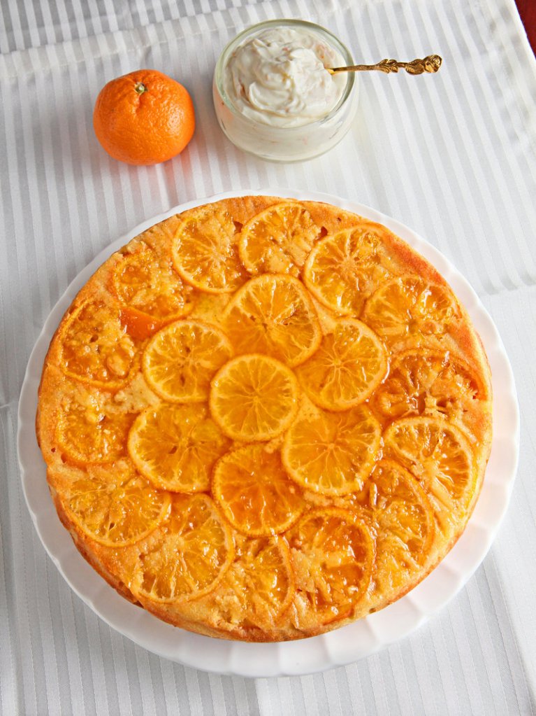 Clementine slices cook on the bottom of this clementine cake, but the finished product is then inverted, showing off the candied citrus, and slices are topped with a dollop of cheesecake cream.