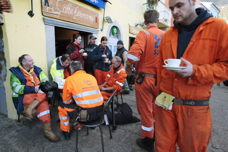 Workers from the Rotterdam-based Smit Salvage company take a break in the port of Giglio on Thursday. The company has yet to win the contract to salvage the Costa Concordia.