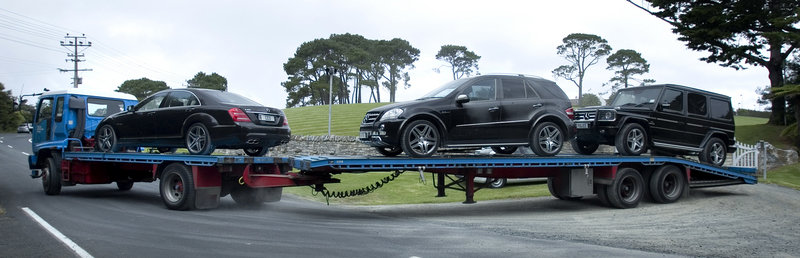 Luxury cars seized from Kim Dotcom in New Zealand are trucked away on Friday.
