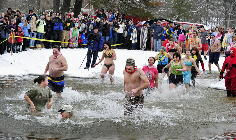 Onlookers cheer during the Freezing for a Reason polar dip at Highland Lake Park in Bridgton on Saturday. About 65 people took part in the event, which raised about $22,000 for the Harvest Hills Animal Shelter in Fryeburg. Patty Murphy of Sweden, who is with Dancing Trees, an Oxford nonprofit, raised $11,000.