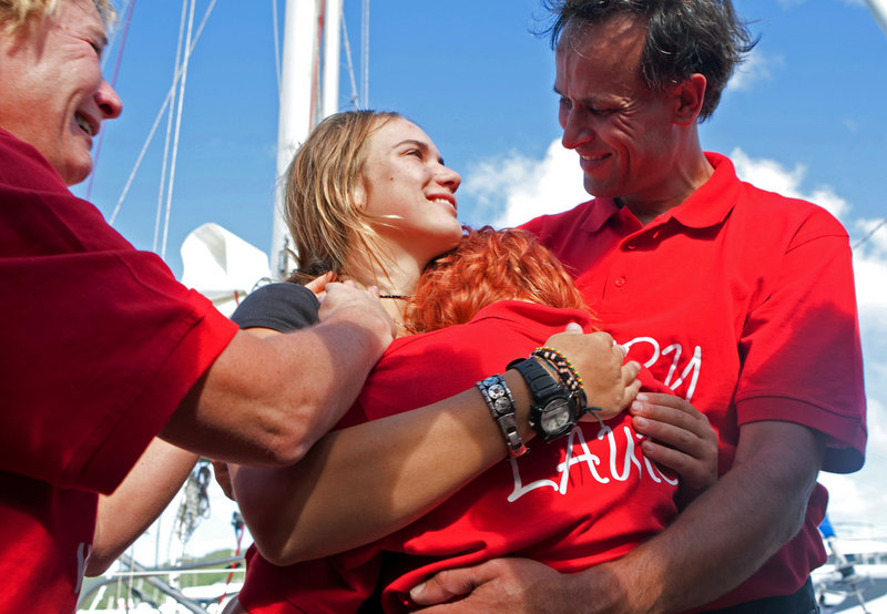 Dutch sailor Laura Dekker, 16, center, is hugged by her father Dick Dekker, right, sister Kim Dekker, front, and mother Babs Muller, left, after arriving at Simpson Bay, St. Maarten, on Saturday. Dekker ended a yearlong voyage aboard a ketch.