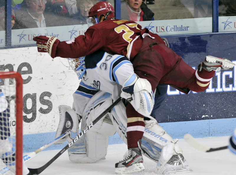 Quinn Smith of Boston College collides with Maine goalie Dan Sullivan in the second period Saturday at Orono. The Black Bears improved to 12-8-3, 9-7-2 in Hockey East with a 7-4 win.