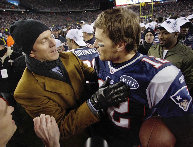 Former Patriots quarterback Drew Bledsoe congratulates Tom Brady after Sunday's victory. Bledsoe served as an honorary captain for the game and presented the AFC championship trophy afterward.
