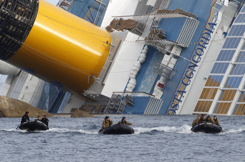 Italian Navy scuba divers head back to shore after working on the grounded cruise ship Costa Concordia off the island of Giglio on Monday. Two more bodies were recovered.