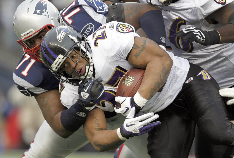 Brandon Deaderick of the Patriots has a firm grasp of Ravens running back Ray Rice during the first half of the AFC championship game.