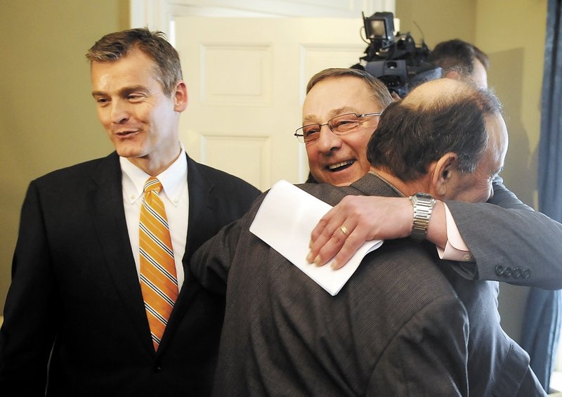 Gov. Paul LePage hugs Bill Alfond on Monday at a ceremony in Augusta after announcing a $10.85 million gift from the Harold Alfond Foundation to the Maine Community College System and Good Will-Hinckley. Good Will-Hinckley President Glenn Cummings is at left. The donation makes possible an expansion of Kennebec Valley Community College in Fairfield.