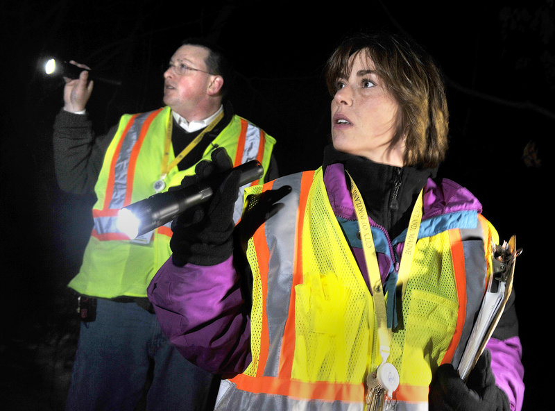 Missy Leeman, right, a councilor from the Oxford Street Shelter, and Josh O’Brien, the shelter’s director, search for homeless Wednesday night in a wooded area along Commercial Street.