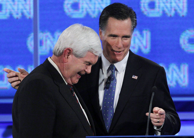 Former House Speaker Newt Gingrich, left, and former Massachusetts Gov. Mitt Romney talk during a commercial break in Thursday night's debate.