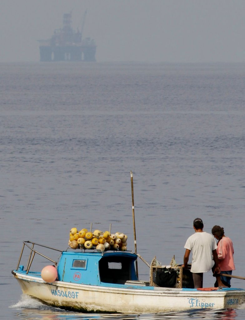 An oil rig floats in the distance as Cuban fishermen work in Havana Bay, Cuba, earlier this month.