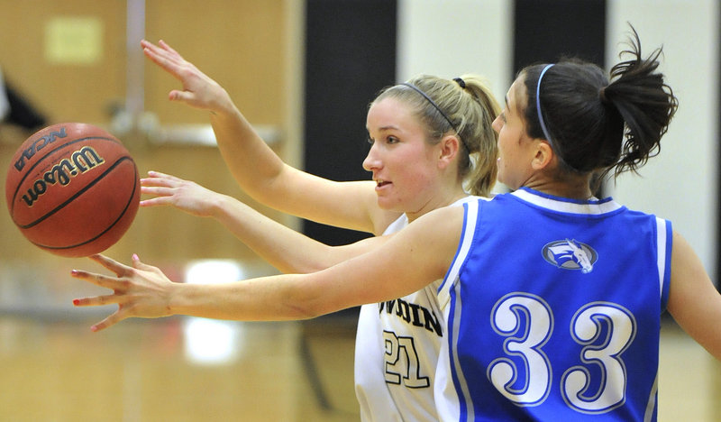Ellery Gould, left, of Bowdoin has the ball knocked loose by Colby’s Jen Nale. Colby had a 32-21 halftime lead, but faltered in the second half.