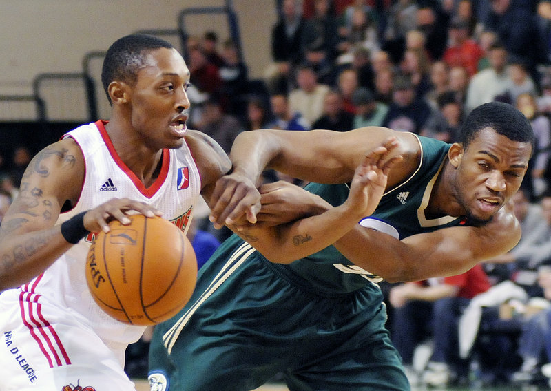 Kenny Hayes of the Red Claws drives to the basket as Reno’s Zachary Graham tries to slow him down during Sunday’s D-League game at the Portland Expo. Reno survived two big comebacks by the Red Claws, holding on for a 105-102 victory.