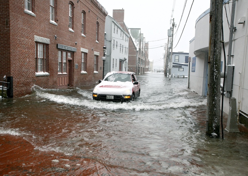 A car drives slowly through the water at high tide on Portland Pier on Jan. 2, 2010. Portland's wharfs and piers are among the areas of the city that could be under water by the end of this century due to higher sea levels brought about by climate change, according to a risk analysis for the city.