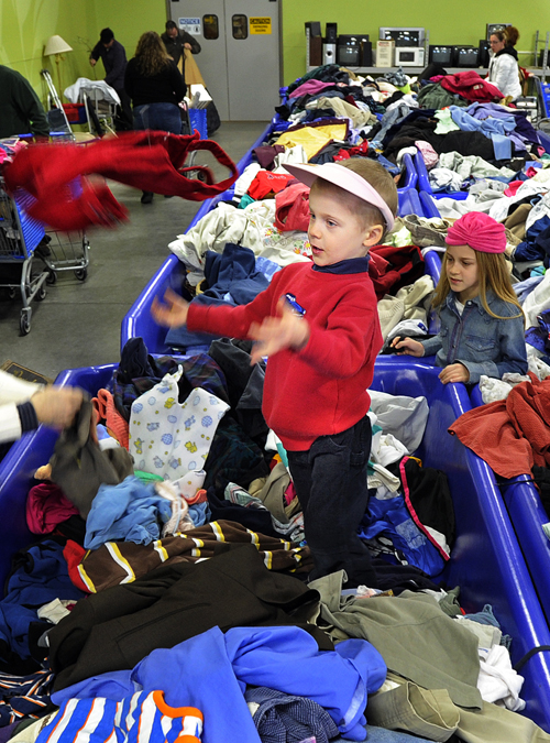Wesley Bosworth, 4, of Hollis, plays in a clothes bin today at Goodwill 's Buy the Pound Warehouse Outlet, while shopping with his family, including 8-year old sister Autumn, left.