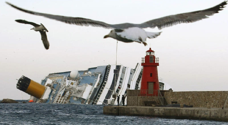 Seagulls fly in front of the grounded cruise ship Costa Concordia off the Tuscan island of Giglio, Italy, on Monday.