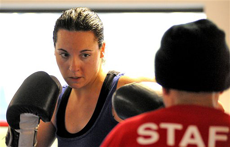 In this Feb. 15, 2012 photo, Ellyn Guinding, 31, of Worcester, Mass. trains with assistant coach Carmelo Torres at the Boys & Girls Club in Worcester. Ellyn will face her fraternal twin sister, Kerri Lewis, in the boxing ring for what promises to be a no-holds-barred slugfest on May 3 at the Worcester Palladium. (AP Photo/Worcester Telegram & Gazette, John Ferrarone)