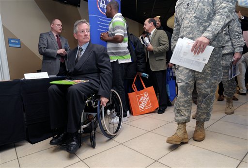 In this Feb. 9, 2012, file photo, disabled army veteran Ken Higgins, of Lilburn, Ga., finishes with a recruiter as he and other veterans attend a military-to-civilian job and education fair held at Turner Field, in Atlanta. General Electric Co. plans to hire 5,000 veterans over the next five years and invest $580 million to expand its aviation business.