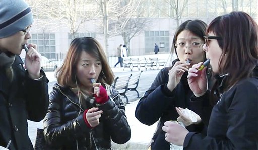 In this Monday, Jan. 23 photo, students try free samples of AeroShot, an inhalable caffeine packed in a lipstick-sized canister, on the campus of Northeastern University in Boston. Harvard University engineering professor David Edwards, created AeroShot, which went on the market in late January. (AP Photo/Rodrique Ngowi)