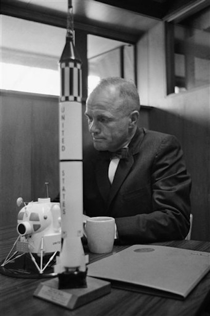 In this Feb. 8, 1963 file photo, astronaut John Glenn sits with models of the Mercury spaceship atop its launch rocket and a lunar module. (AP Photo/Ed Kolenovsky) Bow Tie;Close Up;Cup;NASA;National Aeronautics and Space Administration;Politician;Politics;Profile;Seated;Senator;Sitting