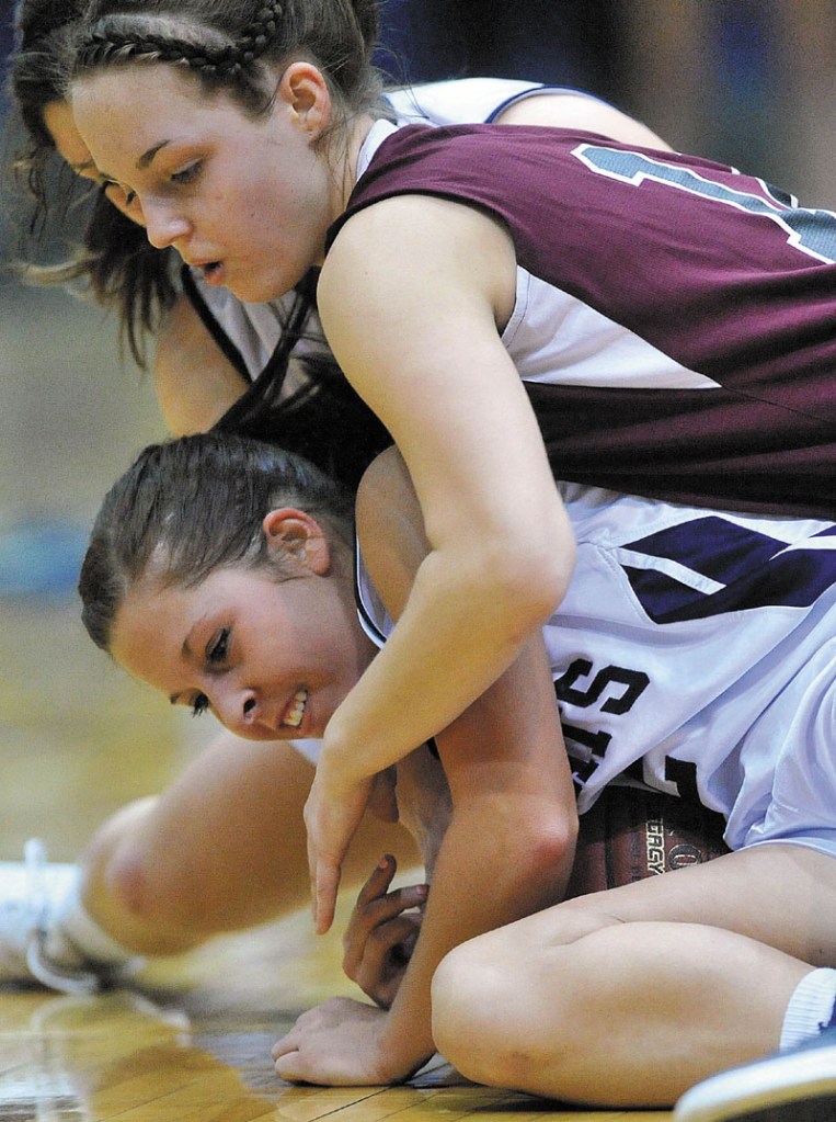 Kylie Richards, top, of Nokomis battles for a loose ball with Presque Isle’s Chelsea Nickerson in the Eastern Class B championship game at the Bangor Auditorium. Nokomis, which was aiming for its third straight regional title, lost 52-40.