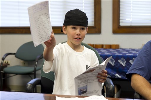 Nine-year-old West James shows off the diary he kept while sailing across the Pacific on Thursday in Honolulu. James, his father, and uncle were attempting their first voyage across the Pacific in a sailboat when rough seas damaged their boat hundreds of miles from land.
