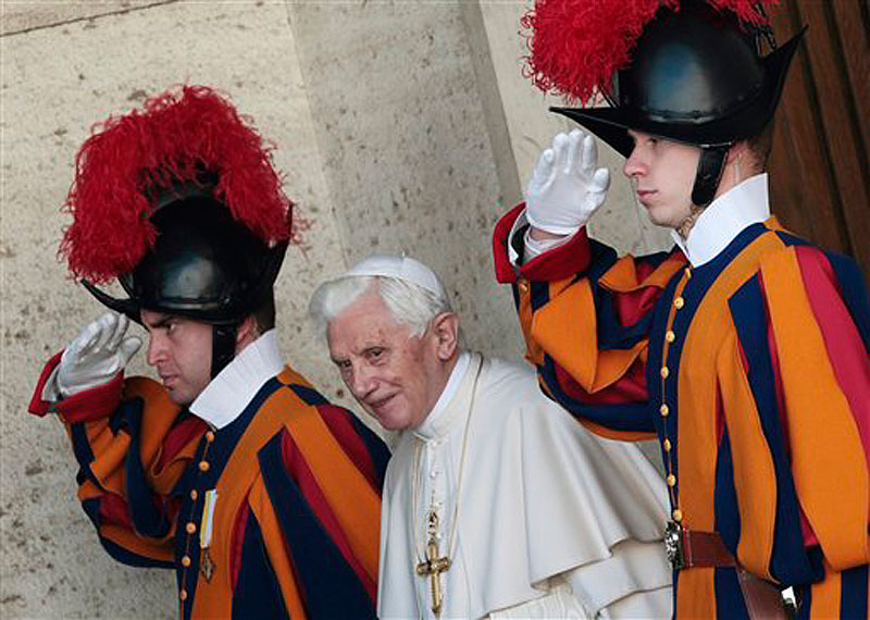 Pope Benedict XVI is saluted by Swiss guards as he leaves the Synod hall after a meeting with Cardinals and Bishops at the Vatican on Friday, Feb. 17. The Pontiff is scheduled to name 22 new Cardinals in a Consistory, Saturday Feb. 18, at the Vatican. (AP Photo/Gregorio Borgia)
