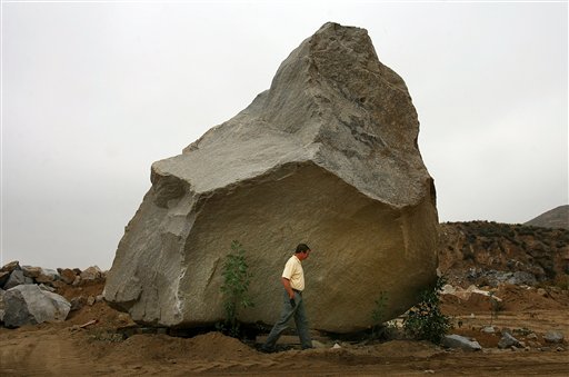 In this June 9, 2011, photo, Stephen Vander Hart, co-owner and vice president of Stone Valley Materials, walks past the 340-ton boulder in his quarry in Riverside, Calif.