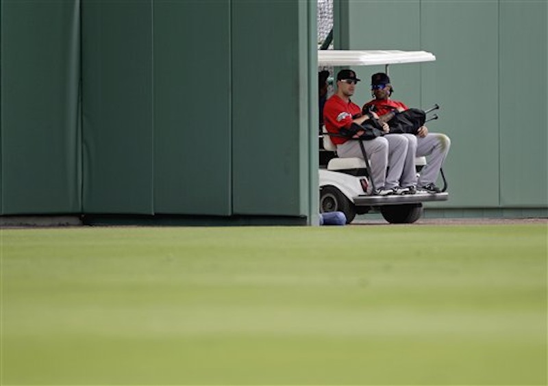 Boston Red Sox's Ryan Kalish, left, and Darnell McDonald are driven out of the ball park on a golf cart to a practice field during a baseball spring training workout Tuesday, Feb. 28, 2012, in Fort Myers, Fla. (AP Photo/David Goldman)