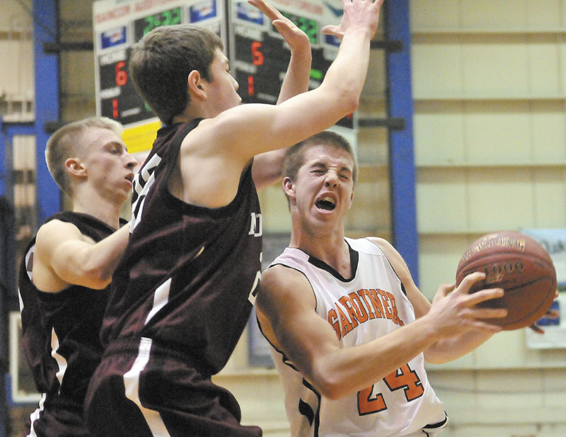 Gardiner's Matt Hall, right, drives the lane as Andrew Cartright, center, and Drew Wing of Nokomis try to defend.