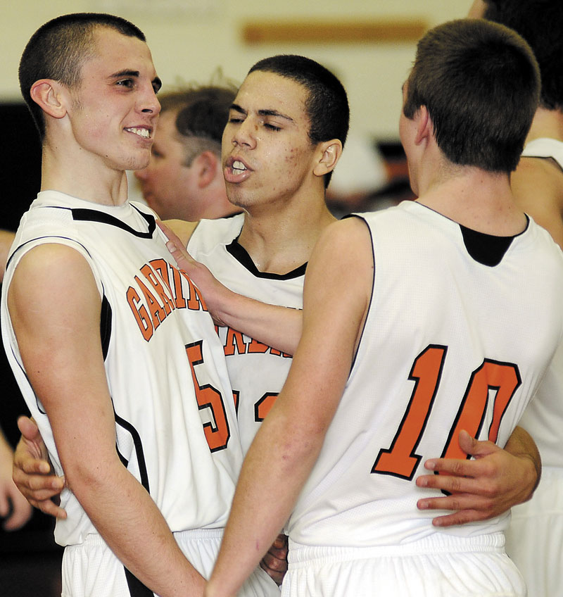READY TO GO: Gardiner Area High School’s Jake Palmer, left, Alzonzo Connor, center, and Justin Lovely celebrate after beating Winslow High School at the buzzer in a game earlier this season. The Tigers finished the regular season 16-2 and face No. 6 Nokomis in a quarterfinal game tonight.
