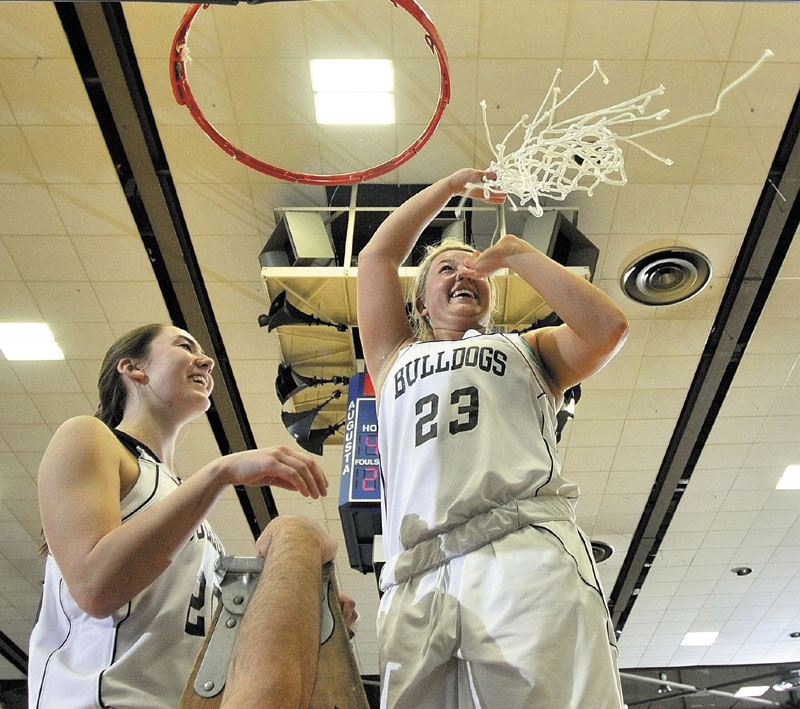 Hall-Dale seniors Paley Sweet, left, and Carylanne Wolfington celebrate atop the ladder after cutting down the nets following the Bulldogs victory in the Western Class C championship game at the Augusta Civic Center.