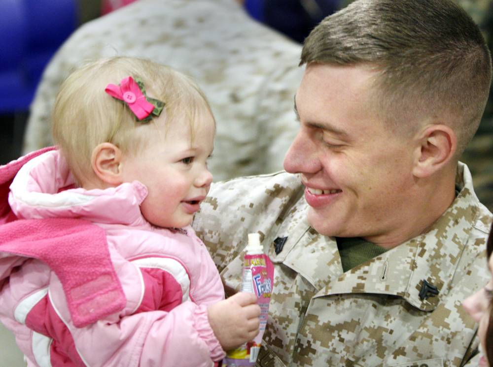 Cpl. Andrew Arseneault of Blue Hill is all smiles Wednesday as he holds his 17-month-old daughter, Arianna, after arriving in Brunswick with of Company A, 1st Battalion, 25th Marine Regiment, 4th Marine Division.