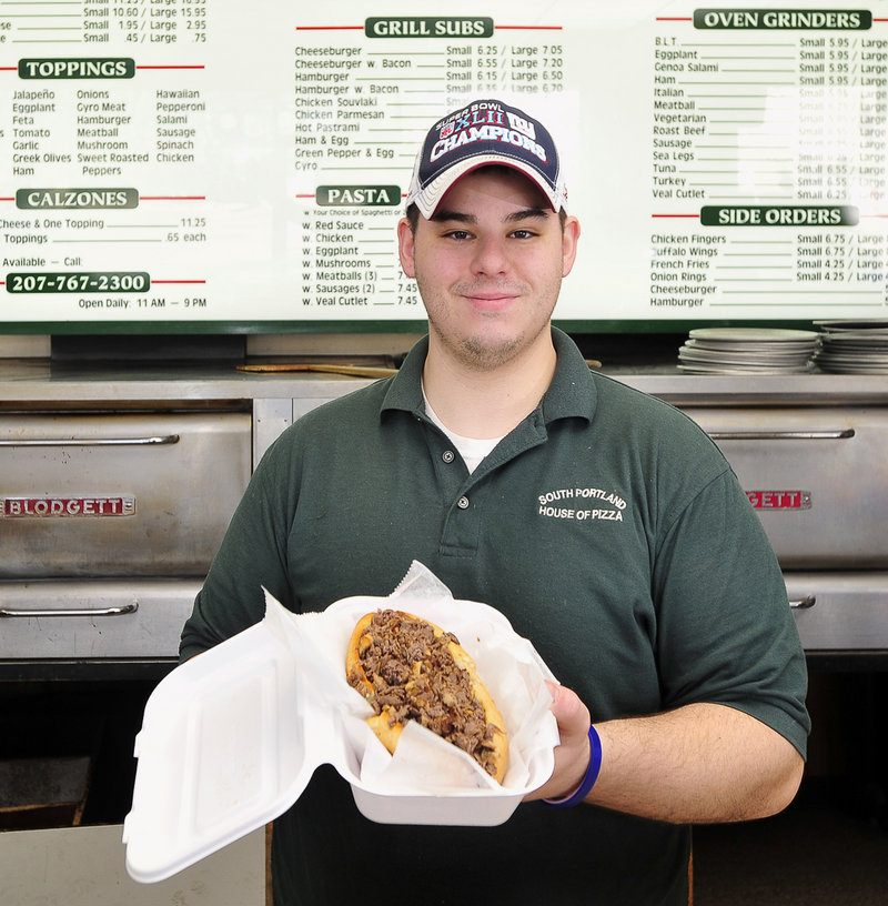 Anthony Bruneau, manager, offers up a steak sub at South Portland House of Pizza.