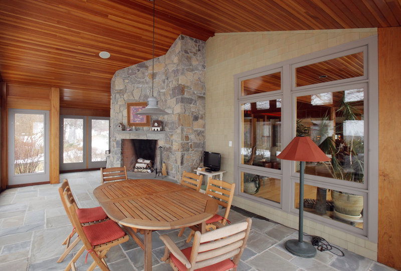 An enclosed porch with a fieldstone fireplace at Jim and Lynn Shaffer’s home.