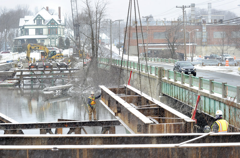 Reed & Reed construction workers build a temporary bridge across the Presumpscot River in Westbrook on Tuesday, a project that will allow traffic to flow while the old, adjacent bridge on Cumberland Street is replaced. The old bridge is to be replaced and ready for use by 2014.